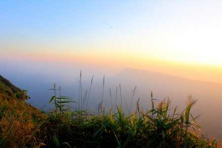 小山和明亮的天空在日落期间