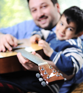 父亲和儿子玩吉他在家里图片