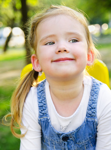 微笑着可爱的小女孩户外的肖像