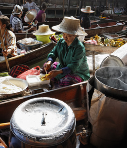 泰国，曼谷，泰国女子切割芒果果实上一艘木船在浮动市场
