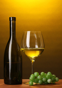葡萄酒瓶和棕色背景上的木桌上的酒杯的组成