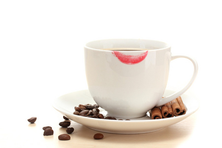 杯咖啡与口红马克豆和肉桂棒上白色隔离