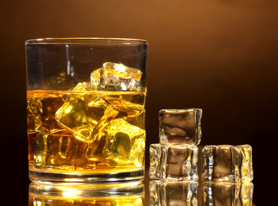 杯威士忌和棕色背景上冰
