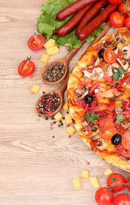 美味的比萨 蔬菜和萨拉米香肠木桌子上