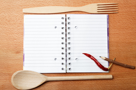 食谱和香料木桌上的笔记本