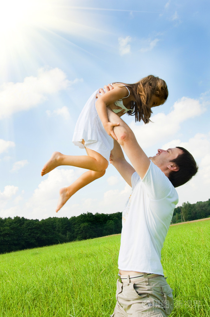 父亲和女儿在草地上玩