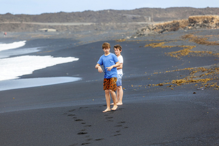 在黑色火山海滩男孩得开心
