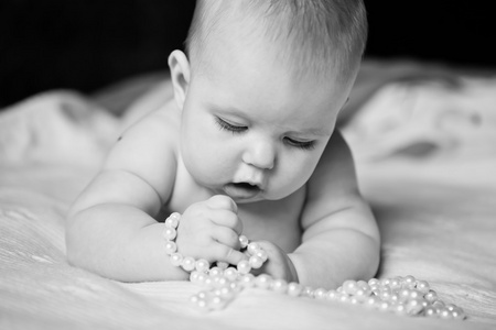 婴儿女孩戏剧与热情珍珠珠躺在肚子上