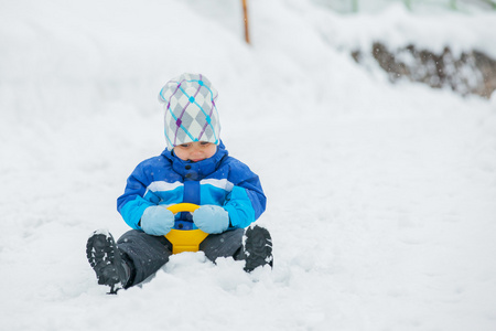 男孩去为驱动器在雪坡上