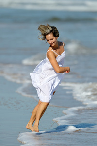 年轻女子在沙滩上慢跑