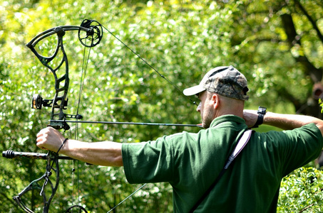 现代弓猎人在森林里照片