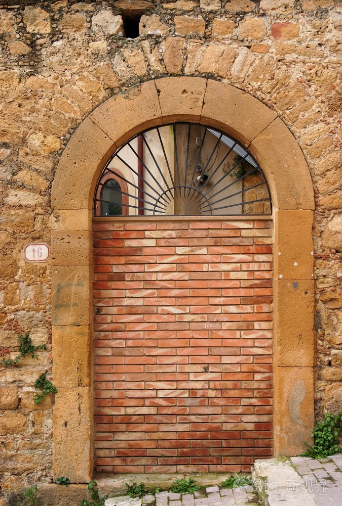 被阻止的砖墙的旧拱形的门