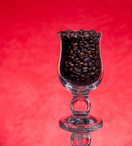 黑烤咖啡在杯子上红色背景中的沙粒