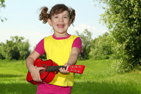 快乐的小女孩弹吉他和唱歌
