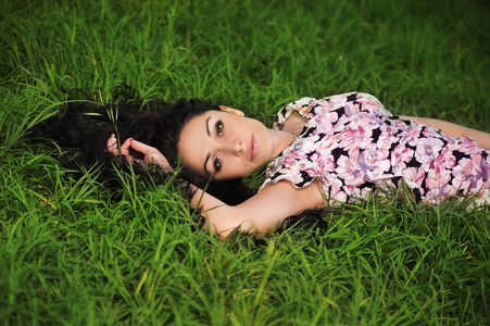 年轻漂亮的女人在草地上的肖像