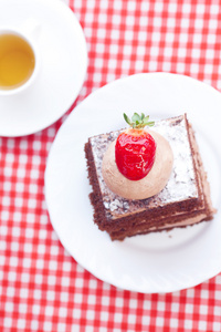 美丽的蛋糕草莓和格子花呢面料上茶