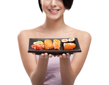 年轻的女孩举行板的寿司和微笑