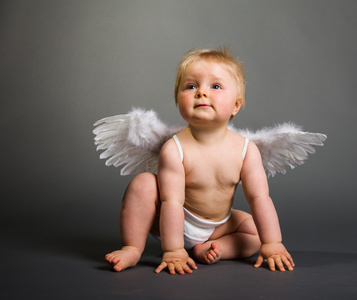 婴儿宝宝与中性背景上天使的翅膀