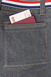 护照和放在蓝色牛仔裤口袋里的空白便笺