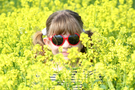 小女孩躲在黄色的花场
