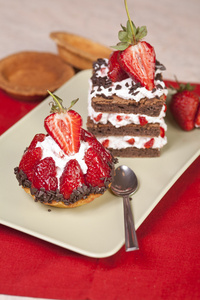 草莓水果塔和板上的分层巧克力草莓蛋糕