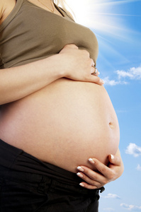 怀孕的女人爱抚着她的肚子里