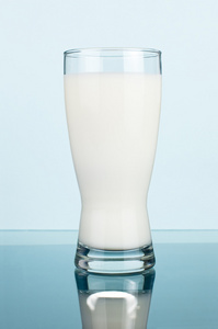 一杯新鲜的牛奶暗青色背景上