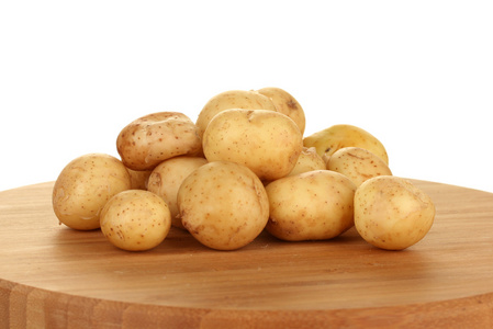 年轻土豆在菜板上白色背景特写
