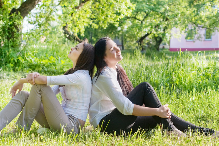 坐在绿草地上的两个女孩