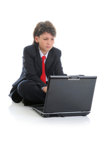 西装坐在计算机前的男孩