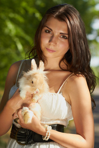 年轻美丽的女孩举行一个兔子