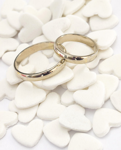 白色的心的背景上的结婚戒指
