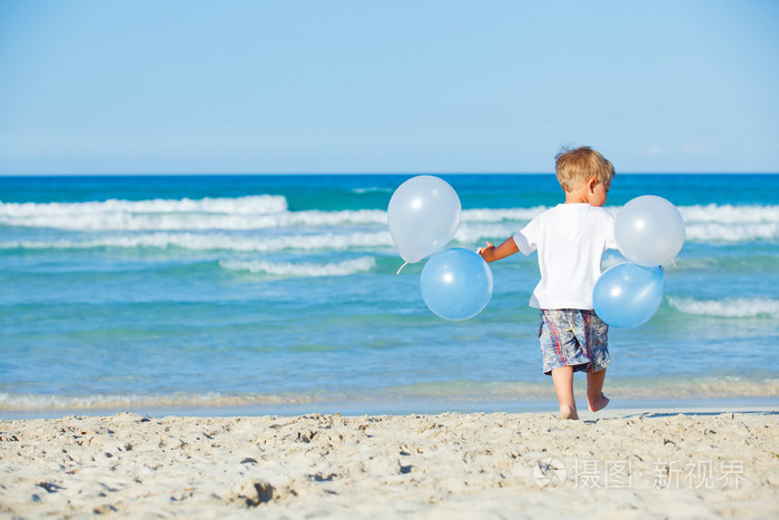 男孩在海滩上玩气球