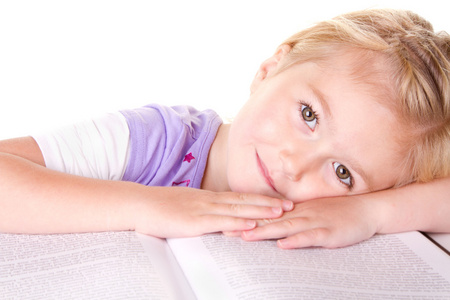 学龄前女孩躺在大书
