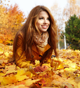 美丽优雅的女人站在一个公园在秋天