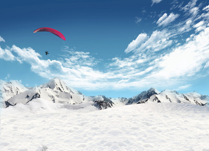 山景观与雪和飞翔在天空的男人
