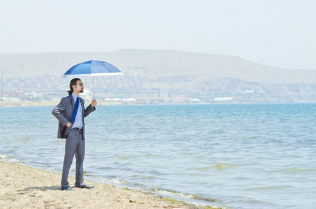 海边沙滩上的伞的男人
