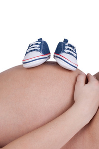 孕妇与蓝色婴儿鞋的特写图片