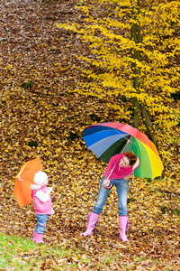 母亲和她的女儿在秋季自然遮阳伞
