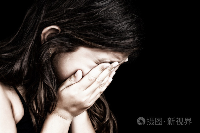 一个女孩哭泣和隐藏她的脸上的肖像