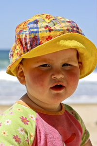 可爱的小宝贝女孩坐在海滩上的沙子