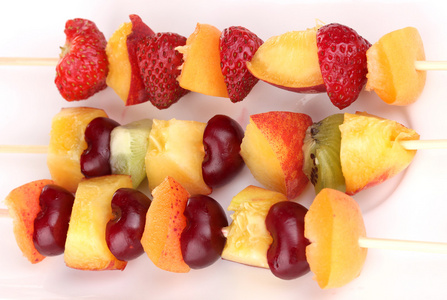 混合的水果和浆果上烤串特写