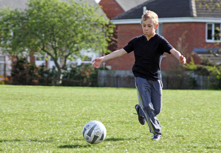 十几岁的男孩在踢足球