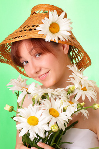 年轻漂亮的姑娘在用洋甘菊花帽子