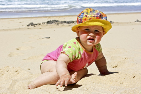可爱的小宝贝女孩坐在海滩上的沙子