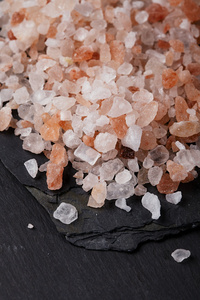 粗粉红色喜马拉雅, 海盐黑色板岩石材背景上照片