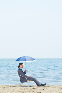 海边沙滩上的伞的男人