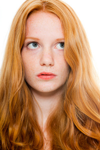 漂亮的女孩与红色的长头发穿褐色衬衫。时装工作室射上孤立的白色背景