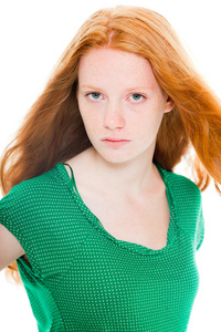 漂亮的女孩与红色的长头发穿绿色的衬衫。自然之美。时装工作室射上孤立的白色背景