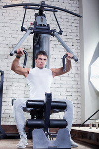 健身俱乐部强大肌肉男子做在健身房举重